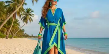 Stylish woman in electric blue and lime green outfit on beach, embodying summer 2026 fashion trends.