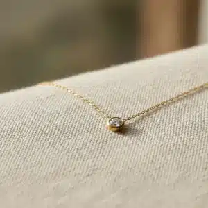 Delicate ethical gold necklace with conflict-free diamond on eco-friendly fabric