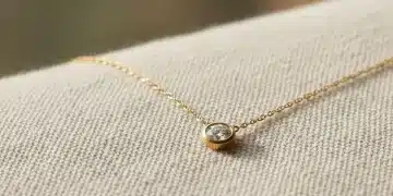 Delicate ethical gold necklace with conflict-free diamond on eco-friendly fabric