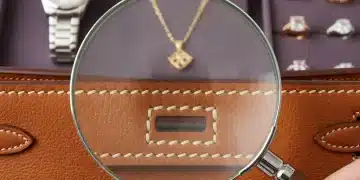 Spotting Fake Luxury Items: 6 Critical Authenticity Checks for 2026 Magnifying glass inspecting stitching on a luxury handbag for authenticity