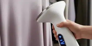 Unlock Your Style: 7 Must-Have Tech Accessories for a Smarter Wardrobe in 2026 Hand using smart portable fabric steamer on silk blouse